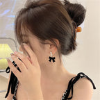 Kolczyki wiszące z perełkami i czarnymi kokardkami