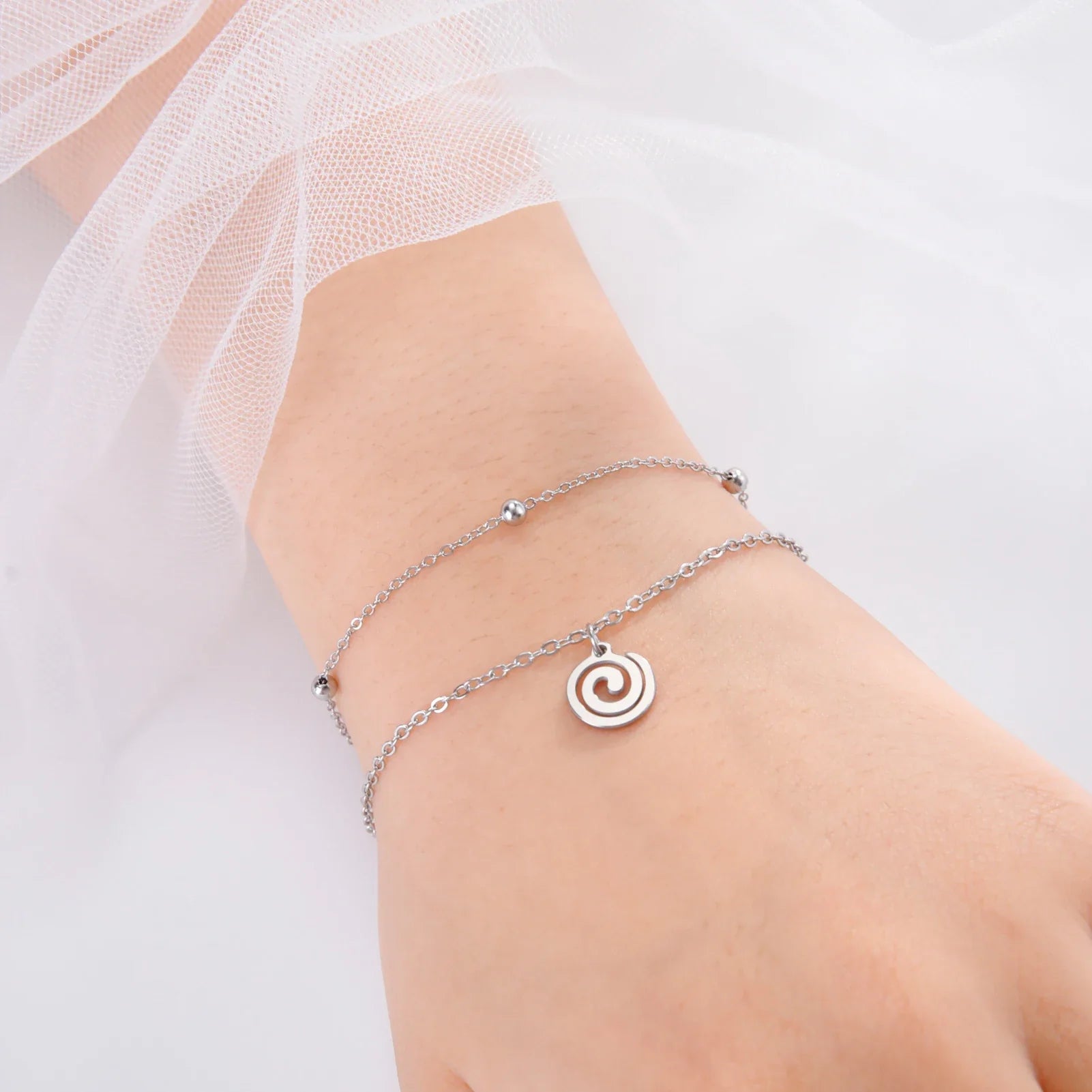 Pozłacana bransoletka z małą zawieszką w kształcie spirali w kolorze srebrnym