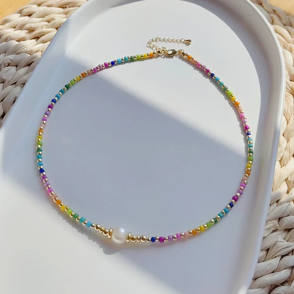 Naszyjnik typu choker z zawieszką w kształcie tęczy i perełkami