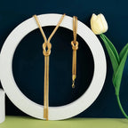 Długi naszyjnik do dekoltu i bransoletka z kokardką 